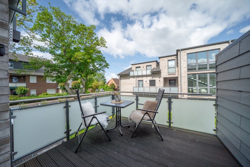 Balkon mit Tisch, Stühlen und Blick über Büsumer Deichhausen