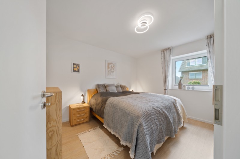 Schlafzimmer mit Doppelbett und Fenster ins Grüne